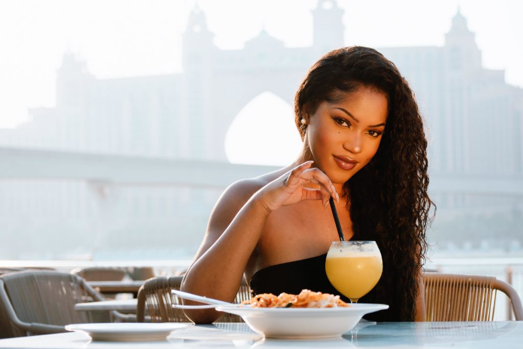 example of an ideal profile picture: woman having lunch with a touristic attraction in the background