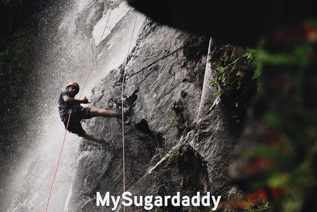 man following his passion climbing waterfall