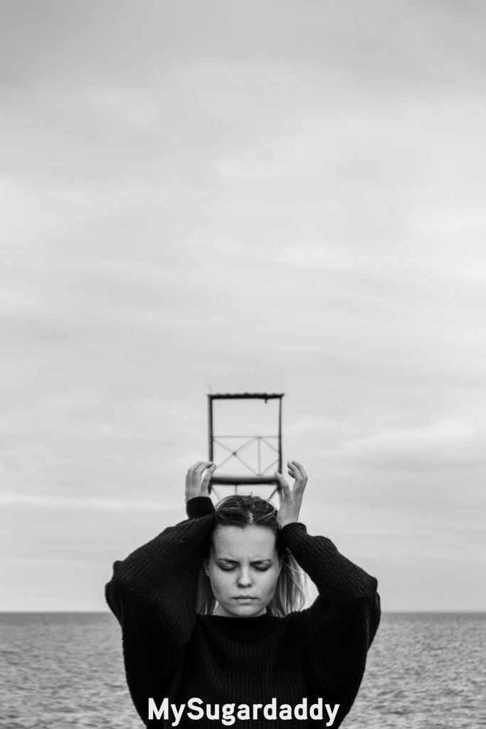 woman reflecting on life with her hands on her head near the sea